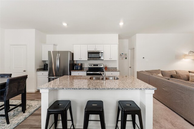 10138 California Lily Ln, Houston, TX 77016 - kitchen with stainless steel appliances, a kitchen breakfast bar, white cabinets, an island with sink, and open floor plan