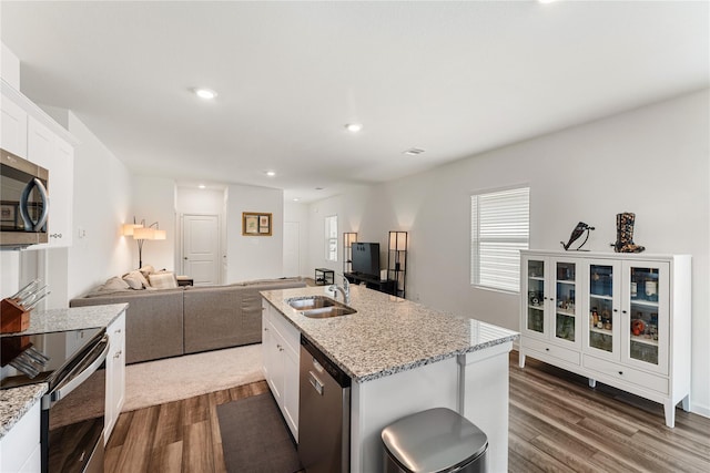 10138 California Lily Ln, Houston, TX 77016 - kitchen with stainless steel appliances, dark wood-style floors, white cabinets, light stone countertops, and open floor plan
