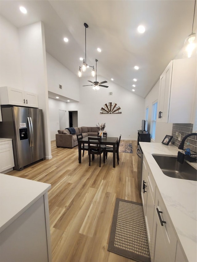 95 Red Tip Ln, Brenham, TX 77833 - kitchen featuring stainless steel fridge, a ceiling fan, white cabinetry, light wood-style flooring, and hanging light fixtures