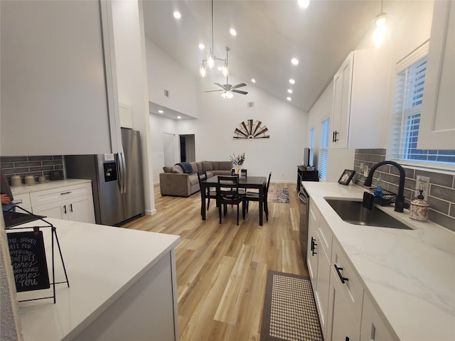 95 Red Tip Ln, Brenham, TX 77833 - kitchen featuring ceiling fan, tasteful backsplash, light wood-type flooring, stainless steel appliances, and white cabinetry
