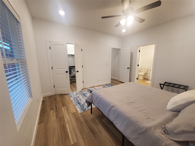 95 Red Tip Ln, Brenham, TX 77833 - bedroom with wood finished floors, ensuite bathroom, multiple windows, ceiling fan, and recessed lighting