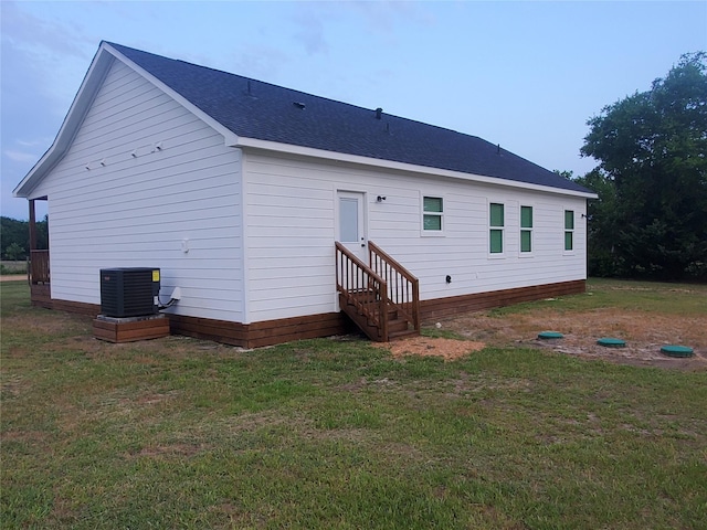95 Red Tip Ln, Brenham, TX 77833 - back of property with a shingled roof, a lawn, and entry steps