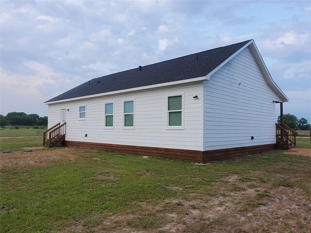 95 Red Tip Ln, Brenham, TX 77833 - back of house with a lawn, a shingled roof, and entry steps