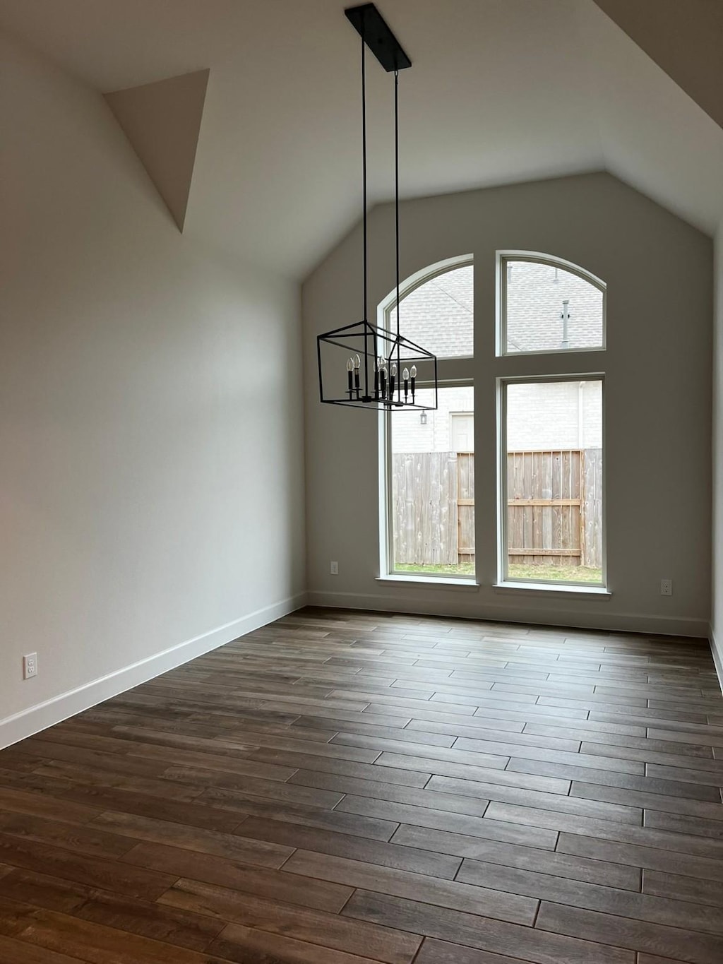 9827 Starry Night Ln, Manvel, TX 77578 - unfurnished dining area with lofted ceiling, a chandelier, and dark wood-type flooring