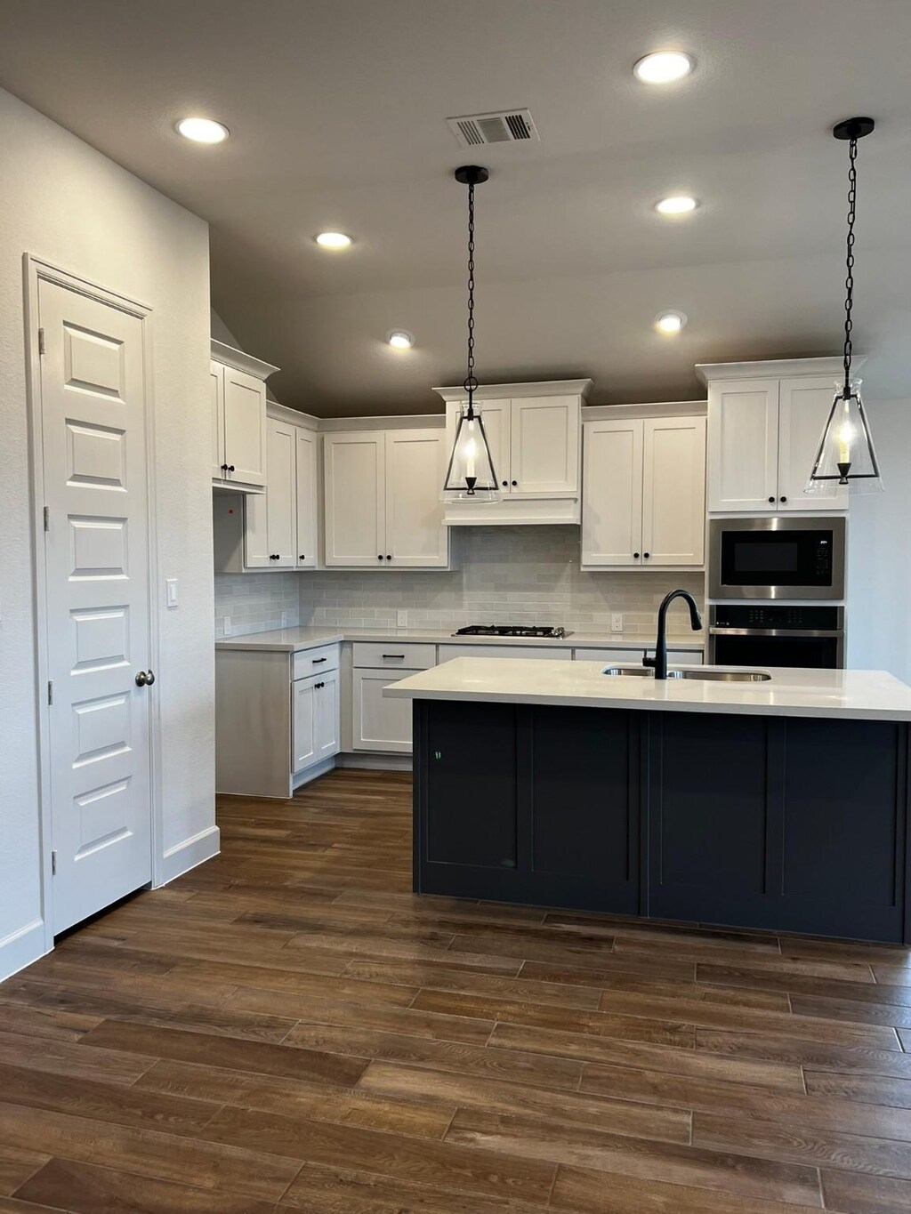 9827 Starry Night Ln, Manvel, TX 77578 - kitchen featuring black microwave, oven, gas cooktop, light countertops, and recessed lighting