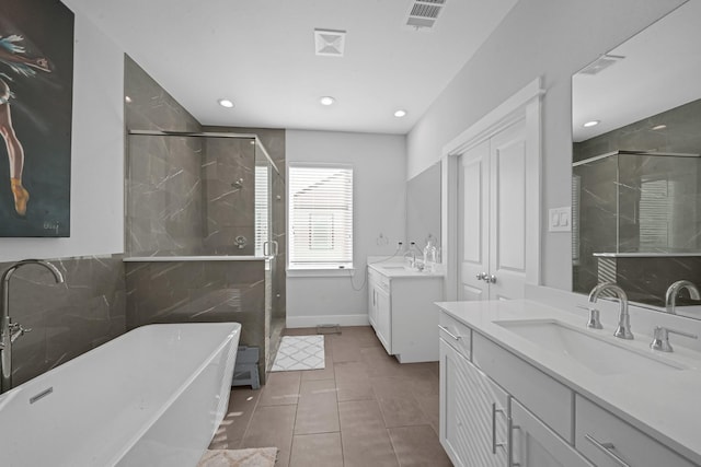 734 W Donovan St, Houston, TX 77091 - full bathroom featuring a stall shower, two vanities, a freestanding bath, recessed lighting, and tile patterned floors