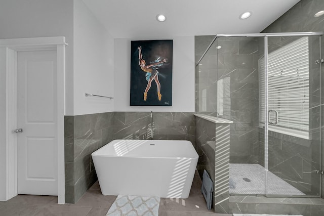 734 W Donovan St, Houston, TX 77091 - full bath with a soaking tub, tile walls, a stall shower, recessed lighting, and a wainscoted wall