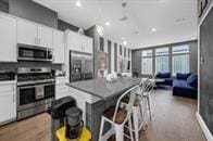 734 W Donovan St, Houston, TX 77091 - kitchen featuring stainless steel appliances, white cabinetry, and decorative light fixtures