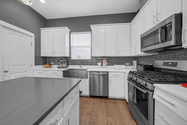 734 W Donovan St, Houston, TX 77091 - kitchen with stainless steel appliances, tasteful backsplash, white cabinets, and light wood-type flooring