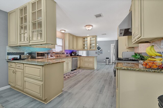 7530 Deep Forest Dr, Houston, TX 77088 - kitchen featuring cream cabinetry, wall chimney exhaust hood, and stainless steel dishwasher