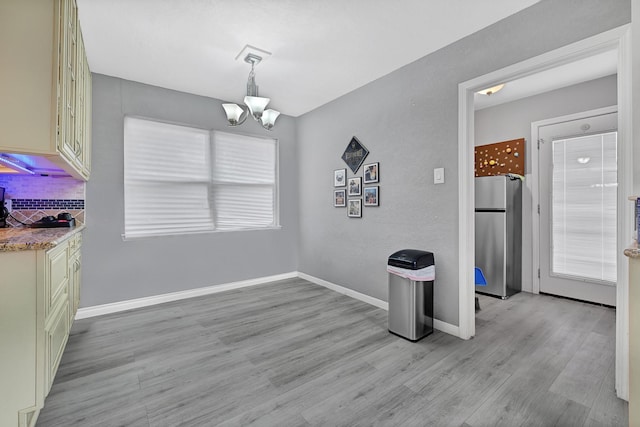 7530 Deep Forest Dr, Houston, TX 77088 - unfurnished dining area featuring a chandelier and light wood-style floors