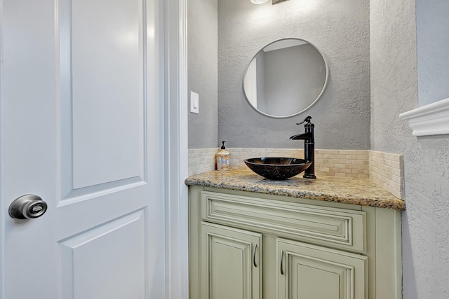 7530 Deep Forest Dr, Houston, TX 77088 - bathroom featuring a textured wall, vanity, and backsplash