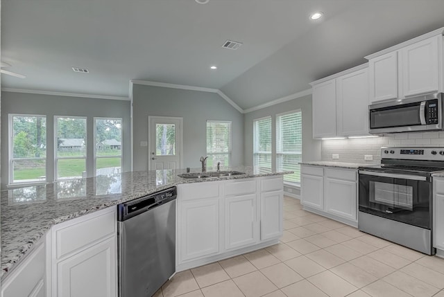 285 Rd 66121, Dayton, TX 77535 - kitchen featuring stainless steel appliances, backsplash, vaulted ceiling, ornamental molding, and white cabinetry