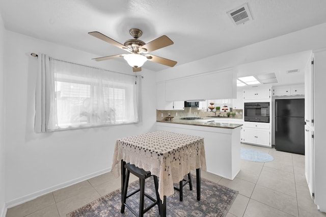27237 Lana Ln, Conroe, TX 77385 - kitchen with black appliances, a peninsula, light tile patterned flooring, white cabinetry, and a ceiling fan