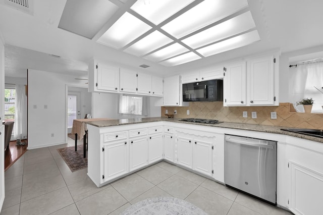 27237 Lana Ln, Conroe, TX 77385 - kitchen featuring dishwasher, black microwave, tasteful backsplash, light tile patterned floors, and a peninsula