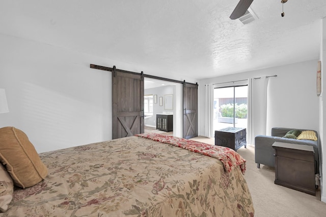 27237 Lana Ln, Conroe, TX 77385 - bedroom featuring access to outside, light colored carpet, multiple windows, a barn door, and a textured ceiling