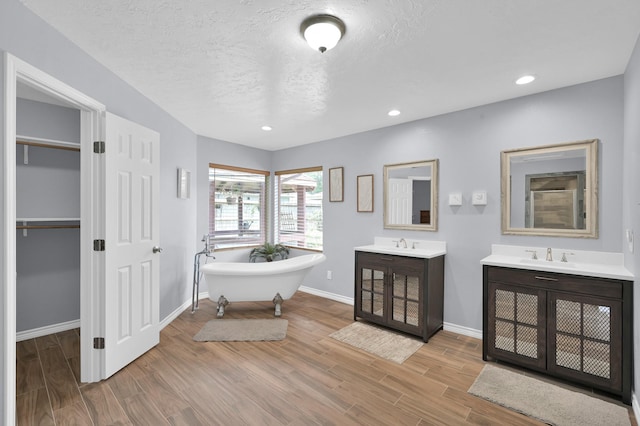 27237 Lana Ln, Conroe, TX 77385 - full bath featuring a soaking tub, wood finished floors, two vanities, recessed lighting, and a walk in closet