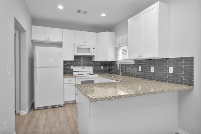 16850 Glenheath, Montgomery, TX 77316 - kitchen with white appliances, light wood finished floors, light stone countertops, a peninsula, and white cabinets