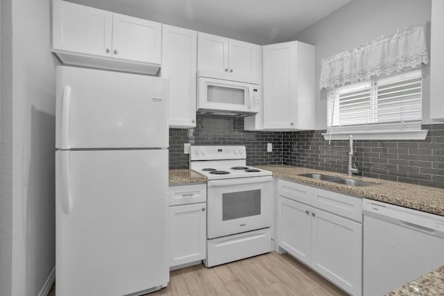 16850 Glenheath, Montgomery, TX 77316 - kitchen with white appliances, white cabinetry, decorative backsplash, light stone counters, and light wood-style flooring