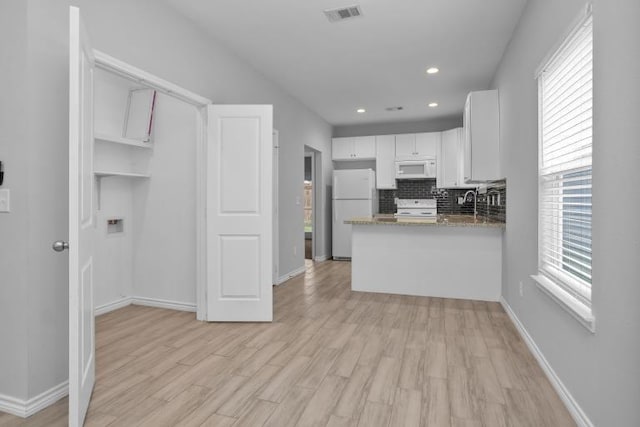 16850 Glenheath, Montgomery, TX 77316 - kitchen featuring white appliances, white cabinetry, light wood finished floors, backsplash, and recessed lighting