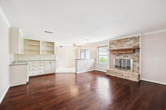 16810 Methil Dr, Spring, TX 77379 - unfurnished living room with crown molding, dark wood-style floors, a fireplace, and ceiling fan