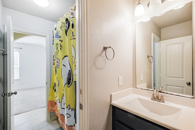 18002 Quarry Vale Dr, Cypress, TX 77429 - bathroom with vanity, tile patterned floors, a textured wall, and a shower with curtain