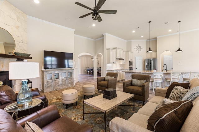 12015 Obsidian Ln, Dayton, TX 77535 - living area with arched walkways, a ceiling fan, light wood finished floors, recessed lighting, and crown molding