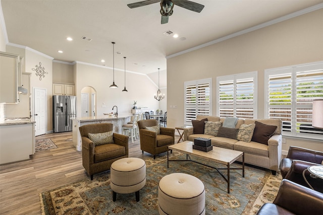12015 Obsidian Ln, Dayton, TX 77535 - living area featuring light wood finished floors, recessed lighting, a ceiling fan, ornamental molding, and arched walkways