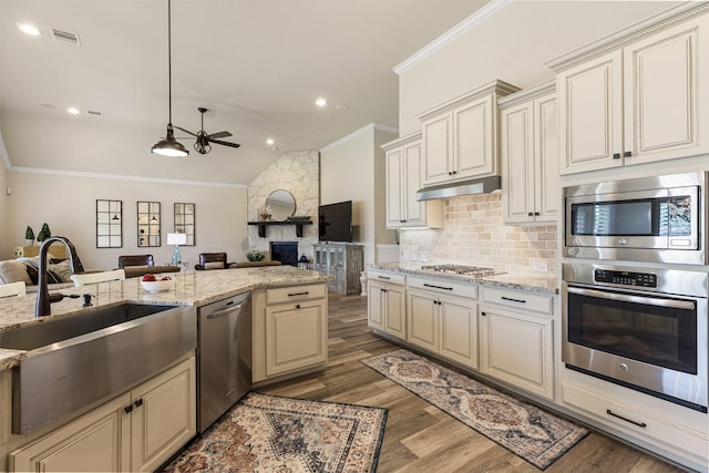 12015 Obsidian Ln, Dayton, TX 77535 - kitchen featuring stainless steel appliances, open floor plan, cream cabinets, ornamental molding, and ceiling fan