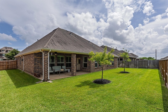 12015 Obsidian Ln, Dayton, TX 77535 - back of property with brick siding, a shingled roof, a fenced backyard, and a patio