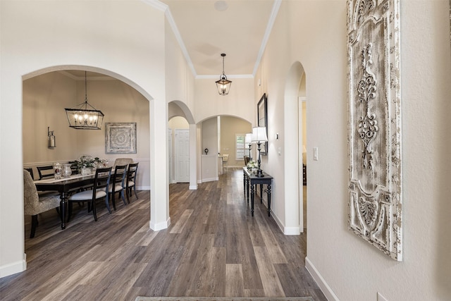 12015 Obsidian Ln, Dayton, TX 77535 - entrance foyer with crown molding, dark wood-style floors, arched walkways, a chandelier, and a high ceiling