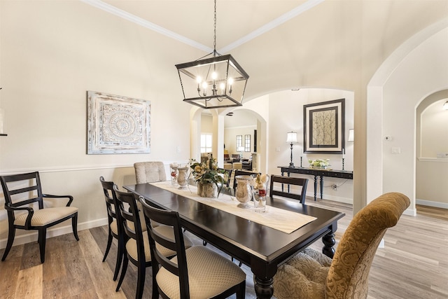 12015 Obsidian Ln, Dayton, TX 77535 - dining area with arched walkways, ornamental molding, wood finished floors, and a chandelier
