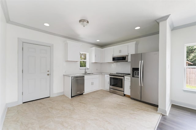 102 Glendale St, Houston, TX 77012 - kitchen with stainless steel appliances, crown molding, white cabinets, light countertops, and backsplash