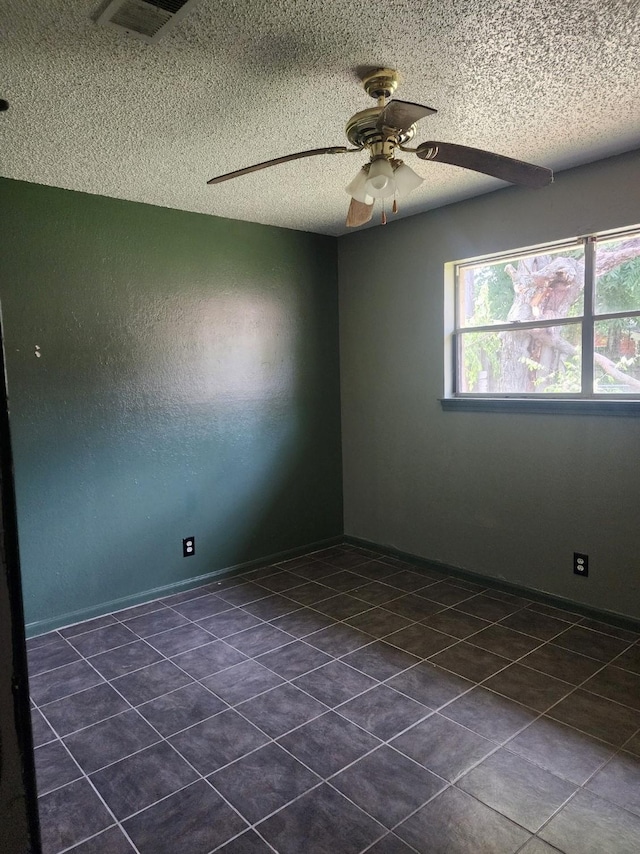 505 Allen Ct, Alvin, TX 77511 - empty room featuring a textured ceiling, a ceiling fan, and dark tile patterned floors