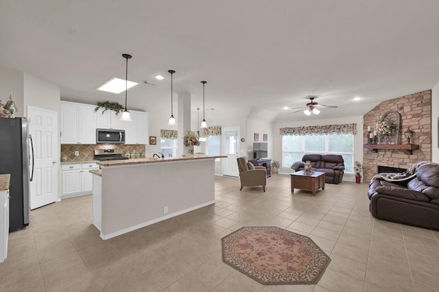 30302 Castle Forest Dr, Spring, TX 77386 - kitchen with appliances with stainless steel finishes, open floor plan, decorative backsplash, white cabinetry, and ceiling fan