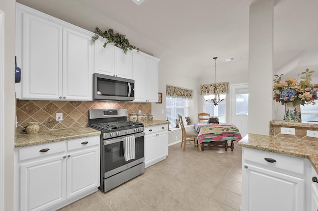 30302 Castle Forest Dr, Spring, TX 77386 - kitchen featuring stainless steel appliances, tasteful backsplash, white cabinetry, a chandelier, and light stone countertops