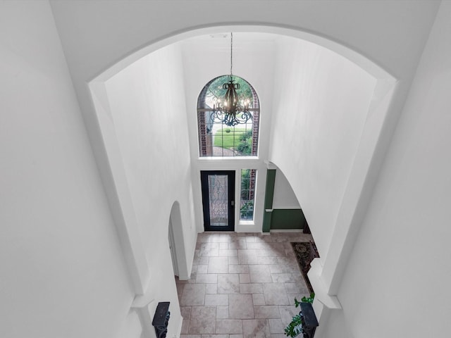 11938 Galentine Pt, Cypress, TX 77429 - foyer entrance featuring a chandelier, stone tile flooring, a high ceiling, and arched walkways