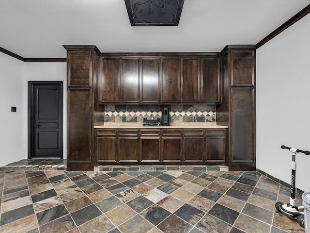 11938 Galentine Pt, Cypress, TX 77429 - kitchen with decorative backsplash, dark brown cabinets, dark stone finish flooring, light countertops, and crown molding