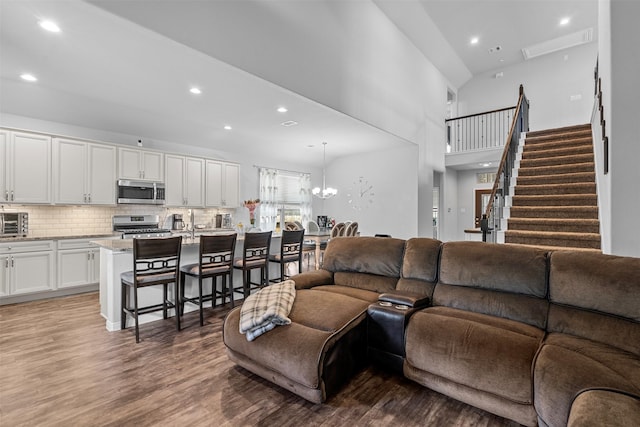 12137 Pearl Bay Ln, Conroe, TX 77304 - living area featuring wood finished floors, recessed lighting, a high ceiling, stairs, and a chandelier