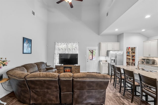 12137 Pearl Bay Ln, Conroe, TX 77304 - living room with ceiling fan, wood finished floors, a towering ceiling, and recessed lighting