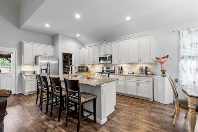 12137 Pearl Bay Ln, Conroe, TX 77304 - kitchen featuring stainless steel appliances, dark wood-style floors, tasteful backsplash, vaulted ceiling, and recessed lighting