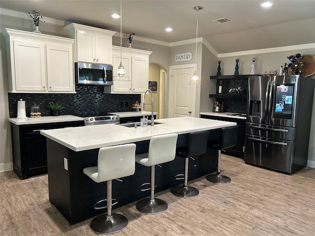 23918 Overcup Dr, Spring, TX 77389 - kitchen with appliances with stainless steel finishes, arched walkways, light countertops, light wood-style floors, and crown molding