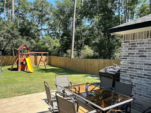 23918 Overcup Dr, Spring, TX 77389 - fenced backyard featuring outdoor dining area, a playground, a patio area, and view of wooded area