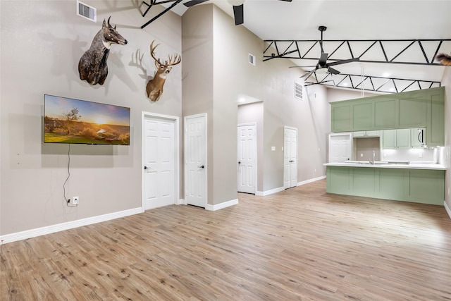 24824 W Christine Dr, Splendora, TX 77372 - unfurnished living room featuring ceiling fan, light wood-style floors, and a towering ceiling