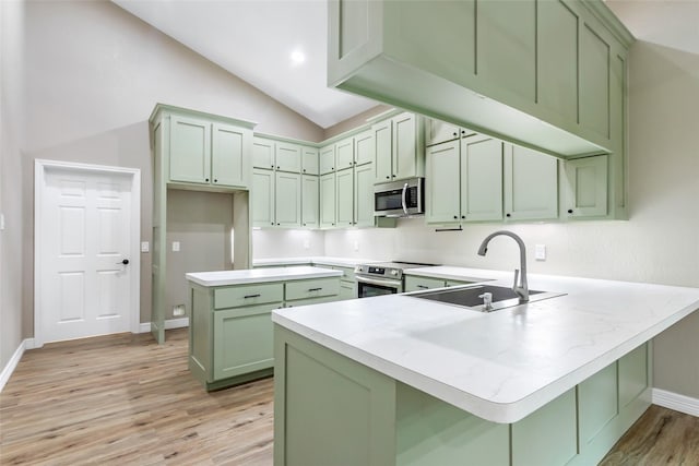 24824 W Christine Dr, Splendora, TX 77372 - kitchen with green cabinets, stainless steel appliances, a peninsula, light wood finished floors, and vaulted ceiling