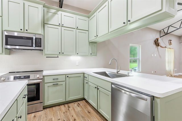 24824 W Christine Dr, Splendora, TX 77372 - kitchen featuring stainless steel appliances, green cabinets, a peninsula, and light countertops