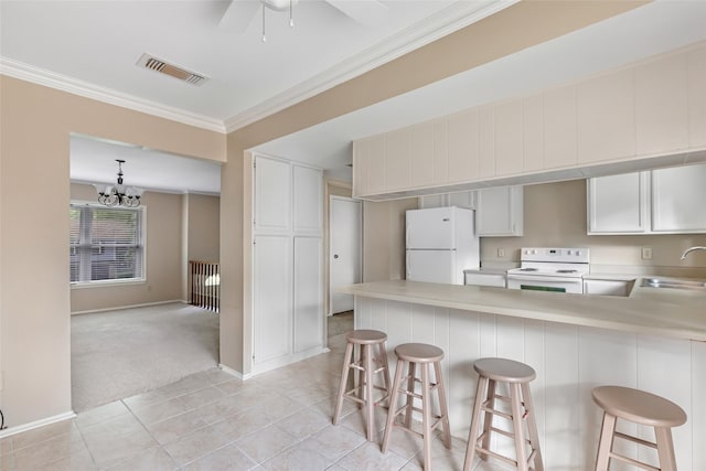 3203 Sycamore Springs Dr, Kingwood, TX 77339 - kitchen featuring white appliances, light countertops, crown molding, a peninsula, and light tile patterned floors