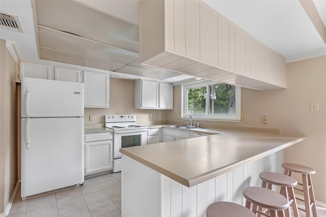 3203 Sycamore Springs Dr, Kingwood, TX 77339 - kitchen with white appliances, a peninsula, white cabinets, light countertops, and a breakfast bar