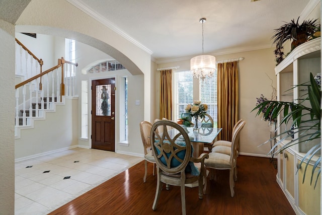 4714 Schiller Park Ln, Sugar Land, TX 77479 - entryway with a chandelier, wood finished floors, stairway, crown molding, and arched walkways