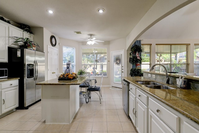4714 Schiller Park Ln, Sugar Land, TX 77479 - kitchen with stainless steel appliances, white cabinets, recessed lighting, light tile patterned floors, and dark stone countertops